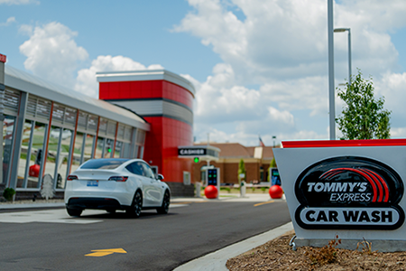 Tommy's Express Car Wash sign with Tesla car in the background