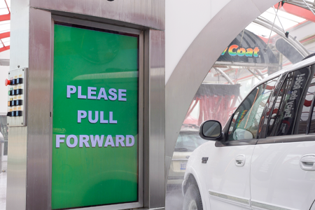 Entrance module at Tommy's Express that reads "Please pull forward"