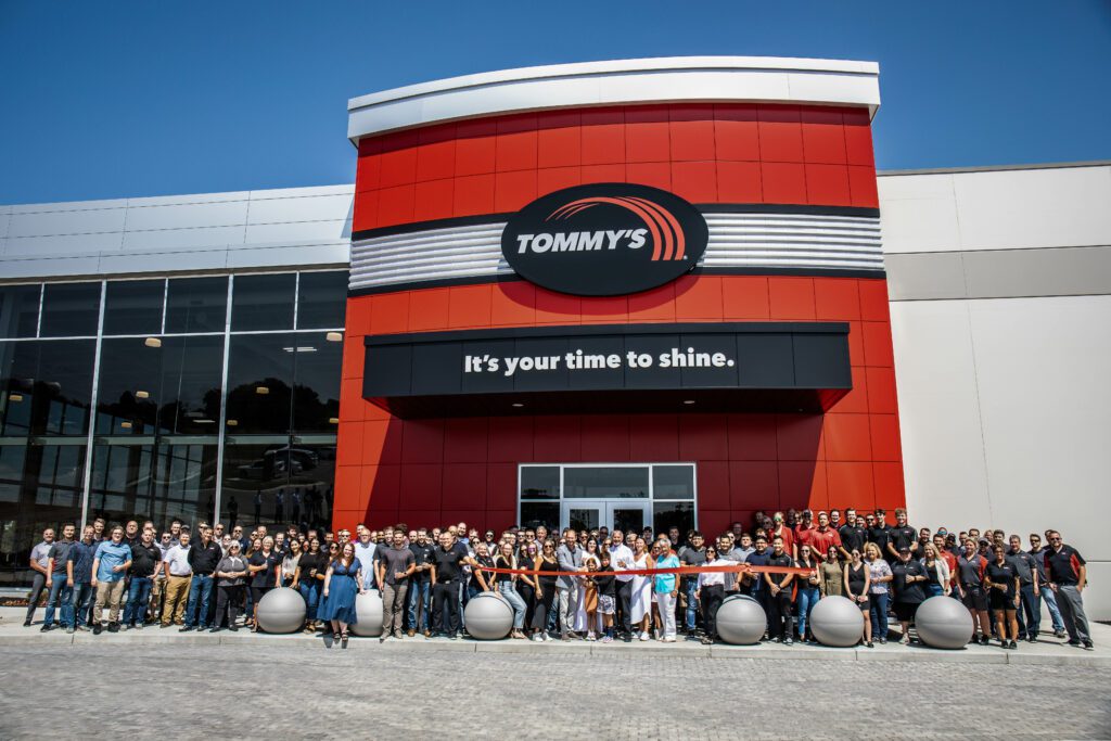 Group of Tommy's Express and Tommy Car Wash Systems employees standing at Tommy's HQ entrance for August 2023 ribboncutting